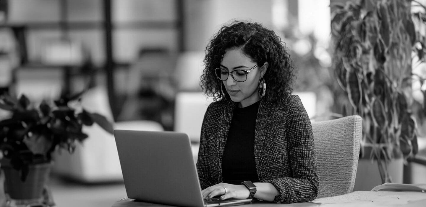 Woman looking down, typing on a laptop