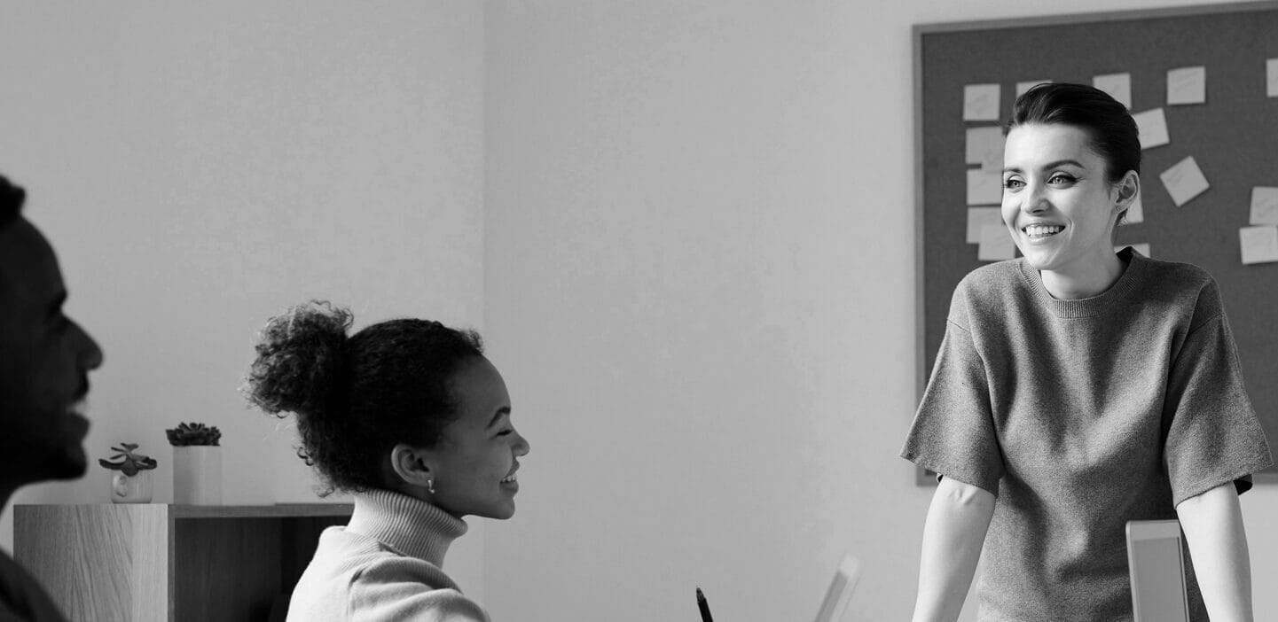 Woman standing up and talking to coworkers