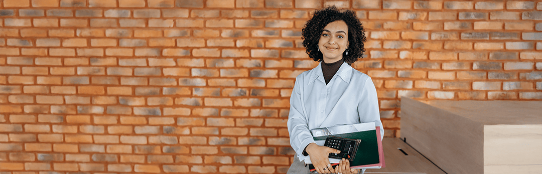 Person sitting in front of a brick wall