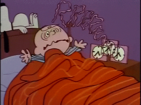 Charlie Brown being awoken by a really loud alarm clock.