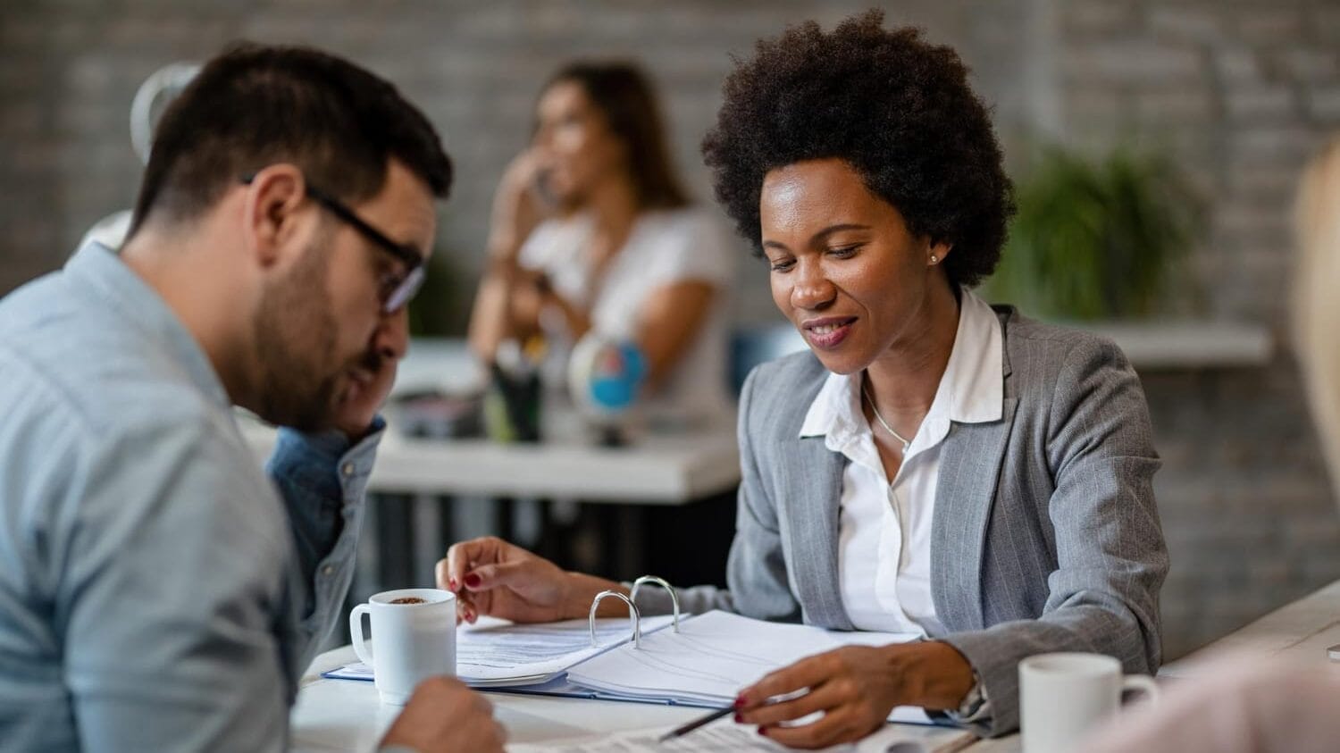 Professional reviewing documents with client for professional indemnity insurance