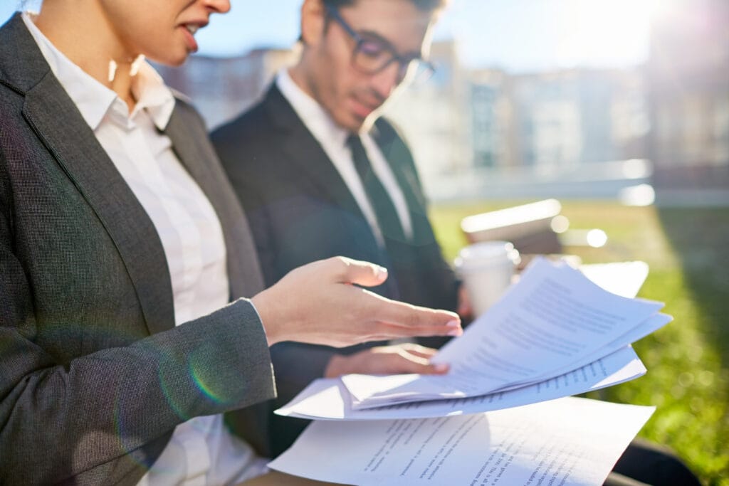 Business professionals analyzing paperwork related to professional liability policy details