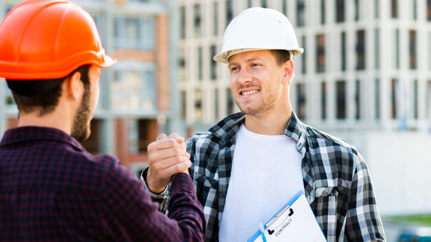 General contractor insurance helps protect construction partners reviewing contract agreement on-site