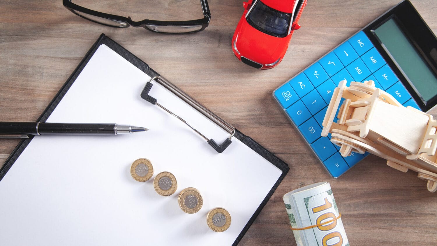 Calculator, money, and documents representing factors affecting LLC insurance cost