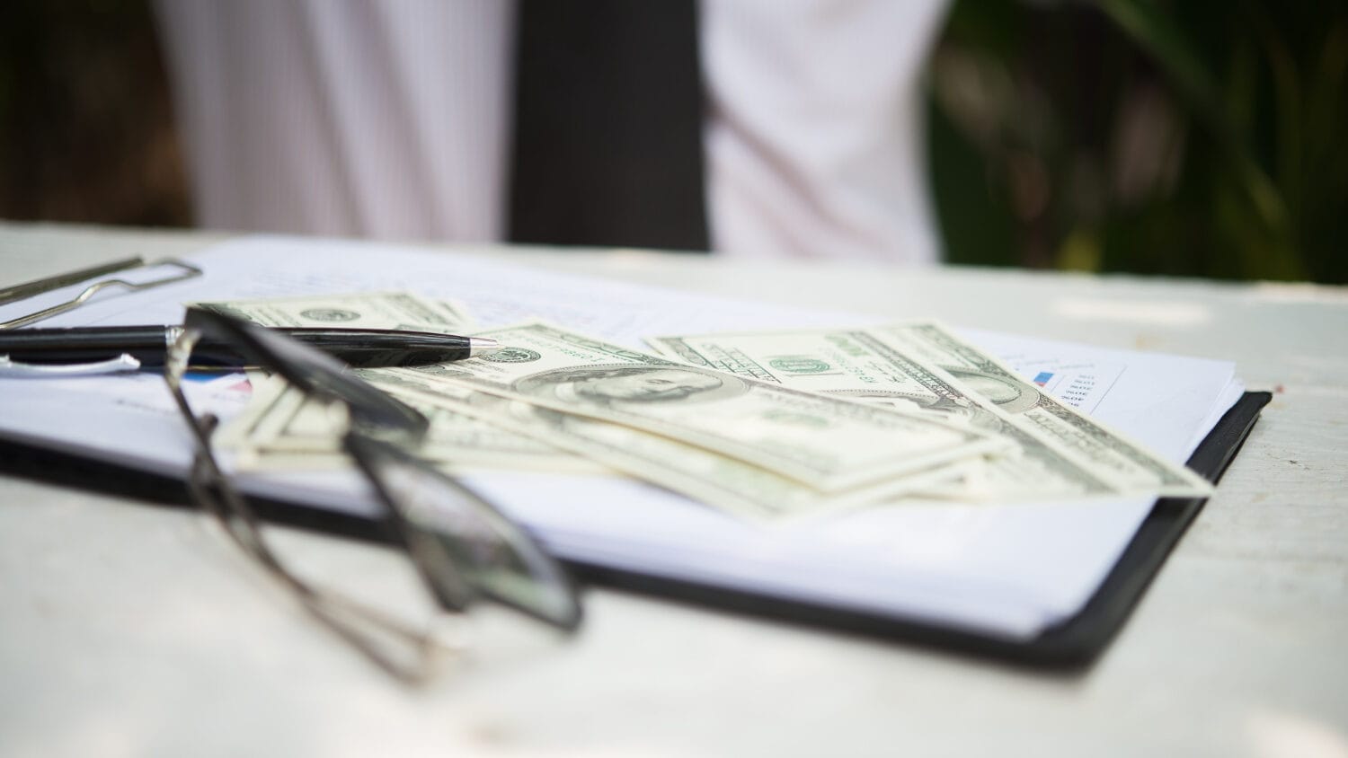 Professional liability insurance cost shown with cash, documents, and office paperwork