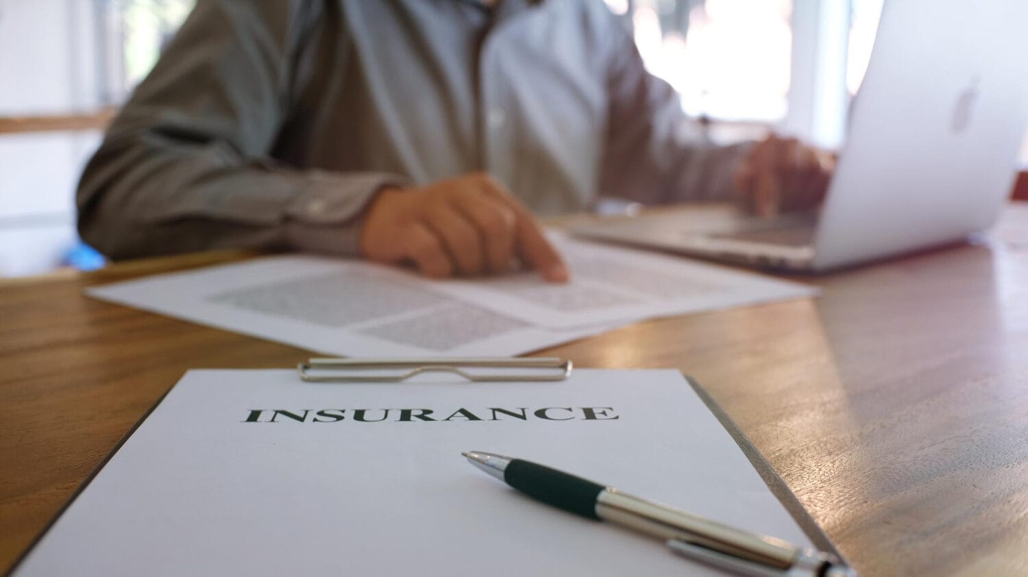 Types of professional liability insurance policy documents reviewed at office desk