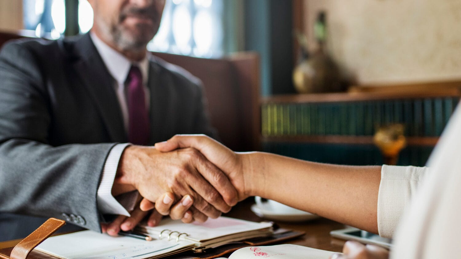 Law firm liability insurance meeting with attorney and client shaking hands