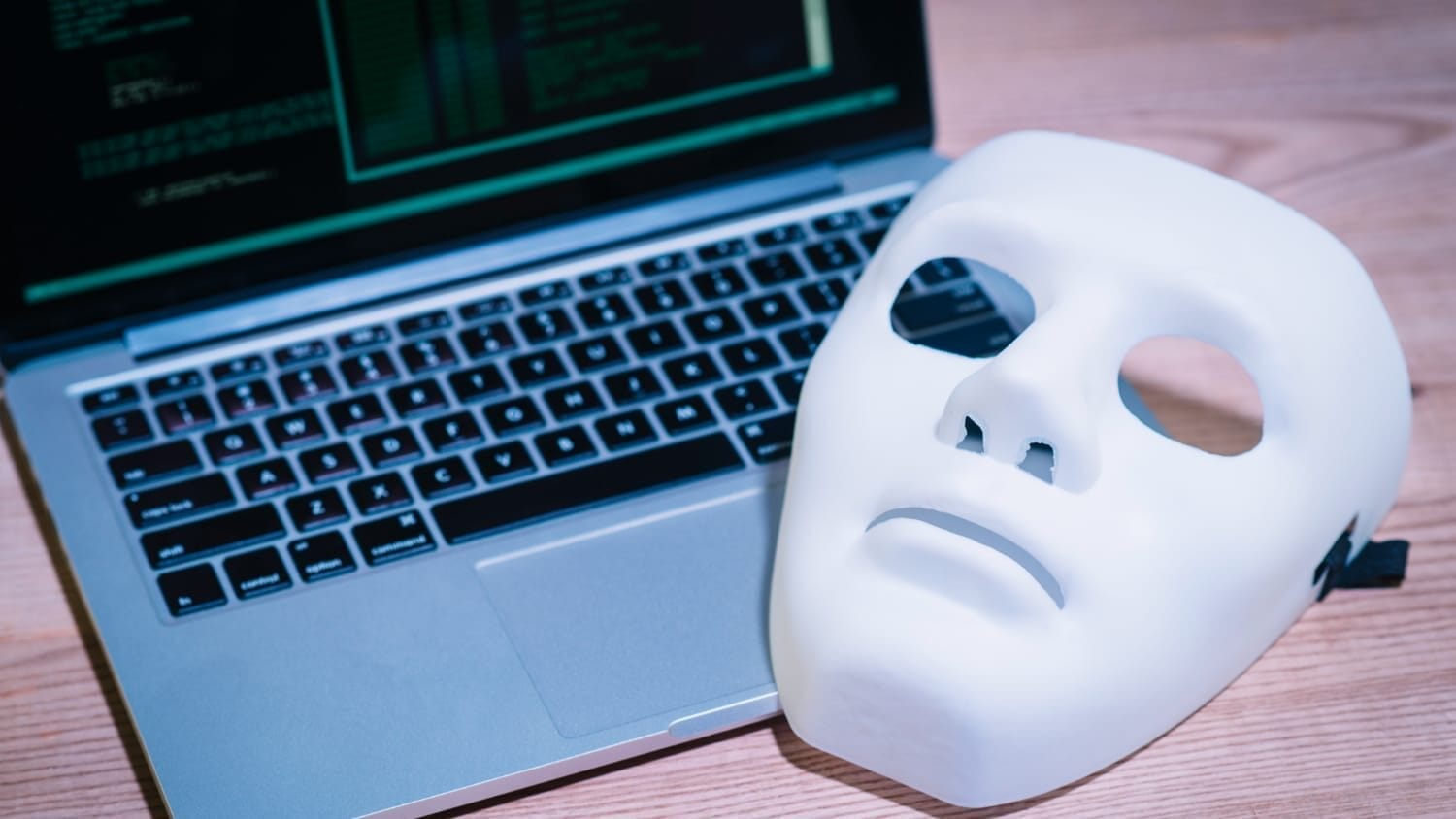 Mask beside laptop with code