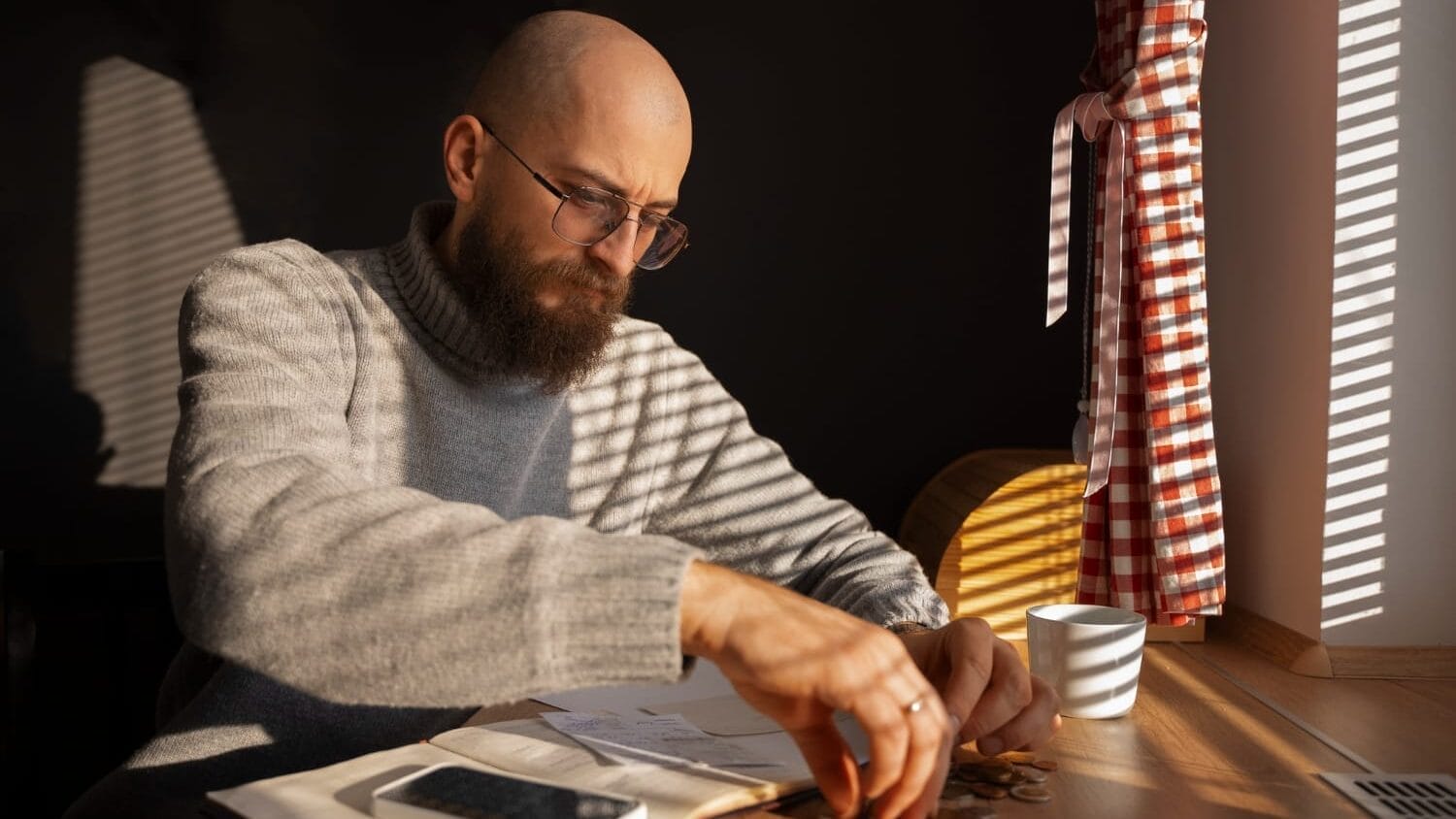 Man calculating expenses at a table, highlighting the Professional Liability (E&O) Insurance Cost surge impact on businesses.